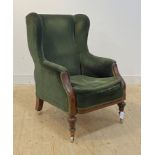 A good mid 19th century mahogany framed wingback armchair, upholstered in bottle green corduroy,