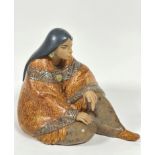 A Spanish Lladro porcelain figure of seated Mexican lady draped with shawl and wearing moccasins,