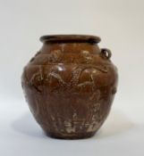 An East Asian treacle glaze earthenware pot with decoration of three-toed dragons in relief, with