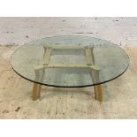 A contemporary designer coffee table, the large circular plate glass top raised on four splayed