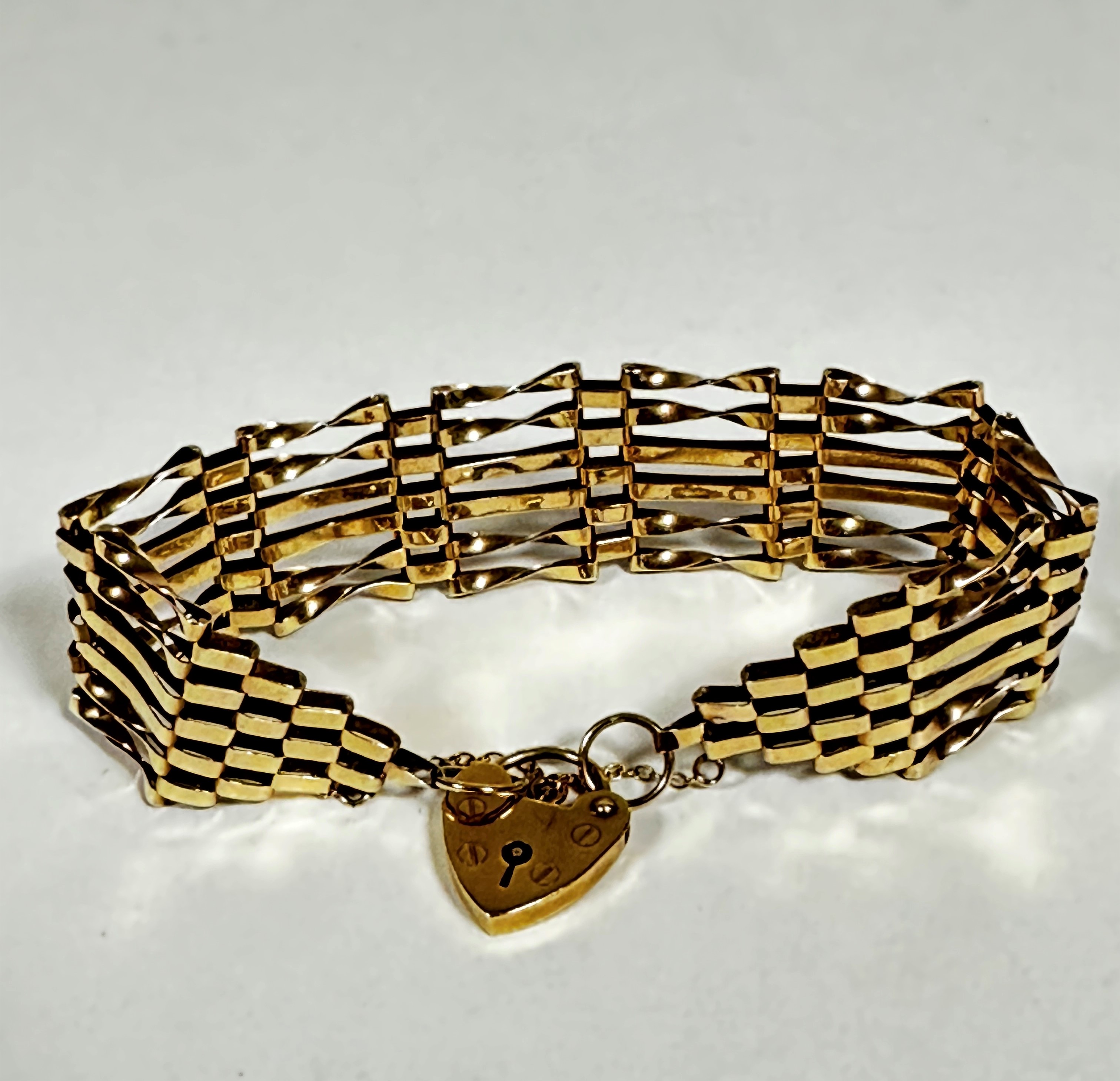 A 9ct gold gate link bracelet complete with heart shaped padlock and safety chain, (w: 8cm) (12.