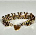 A 9ct gold gate link bracelet complete with heart shaped padlock and safety chain, (w: 8cm) (12.