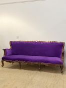 A Baroque style sofa, with undulating crest rail and scrolled arms enclosing purple velvet