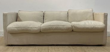 A contemporary three seat sofa of rectangular outline, with loose cover and squab cushions