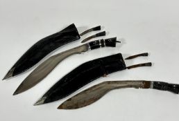 Two steel bladed Kukri ebony handled knives complete with miniature knives, all show signs of