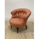 A Victorian tub bedroom chair, upholstered in deep buttoned red damask, raised on turned supports