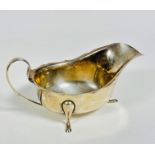 An Edinburgh 1934 silver sauce boat with scalloped border and C scroll handle to sides, raised on