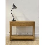 A contemporary oak console table, fitted with two frieze drawers, raised on turned supports united
