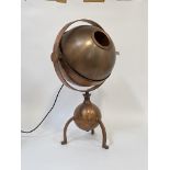 An unusual copper lamp, the shade of spherical form swivelling and revolving over three bowed