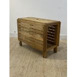 A slatted oak garden table, with drop leaves, moving on castors to one end, H73cm, 95cm x 48cm