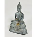 A lead cast figure of a seated Asian Buddha with hands crossed across his knees, seated on lotus
