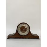 An early 20th century oak cased dome top mantel clock, the silvered dial with Arabic chapter ring,