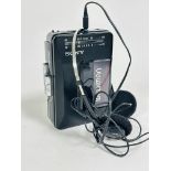 A vintage Sony Walkman FM radio cassette player complete with original ear phones, (13.5cm x 9cm)