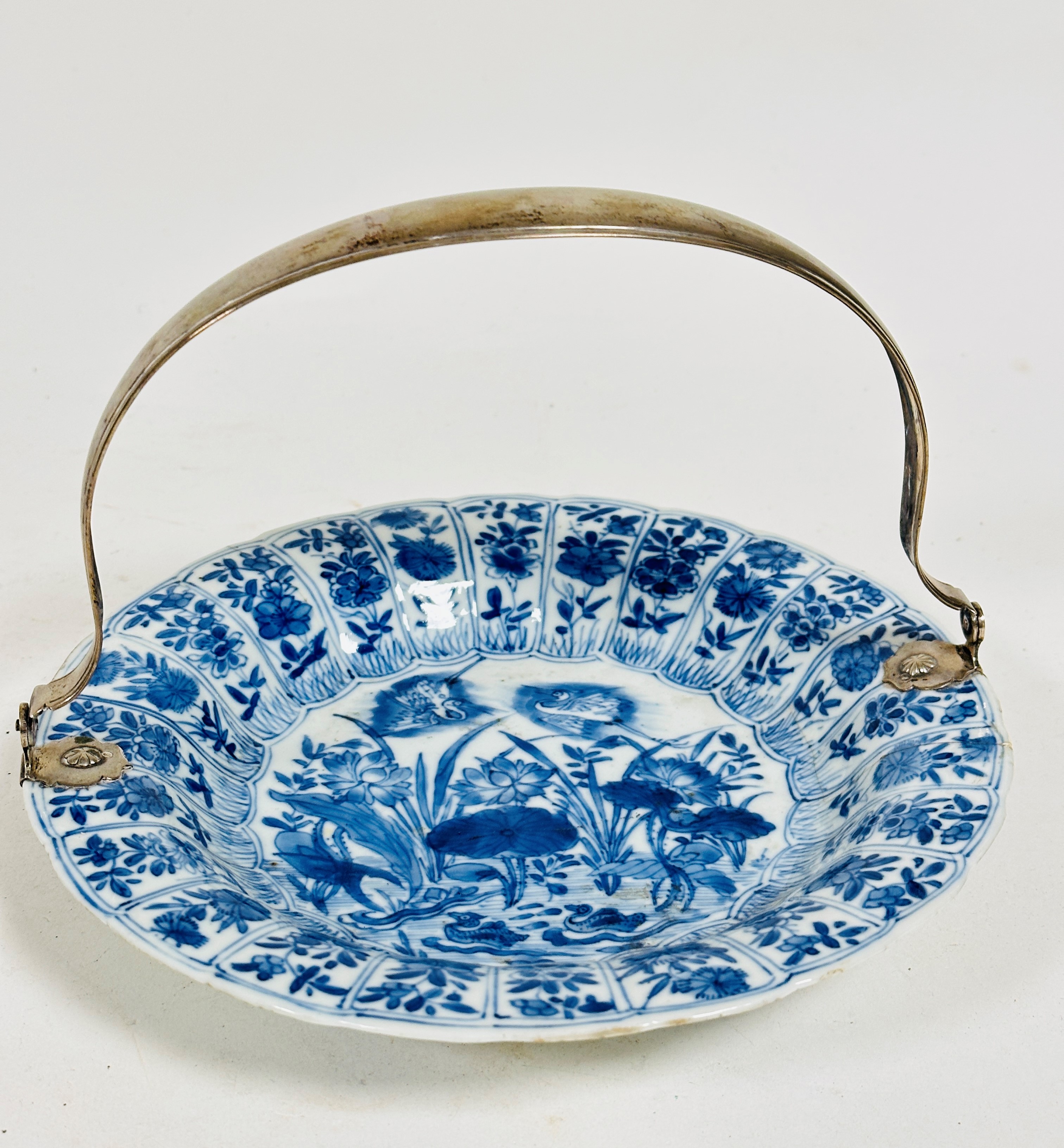 A 19thc Chinese blue and white scalloped dish decorated with central scene with storks and pond,