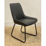 A contemporary side chair, upholstered in channelled black leather, raised on tubular supports,
