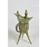 A reproduction bronze verdigris archaic style libation cup with twin prong supports and ring