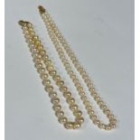 A baroque cultured pearl graduated necklace with 9ct gold millegrain set diamond shell shaped clasp,
