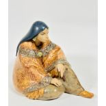 A Spanish Lladro porcelain figure of a seated Mexican lady draped with shawl, wearing moccasins,