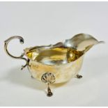 A Chester 1910 silver George III style sauce boat with scalloped border and S scroll handle to side,