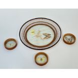 A Japanese circular wicker dish with glass inlay displaying two butterflies and a dried flower (h-