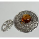 A 19thc style white metal plaid brooch set faceted glass, amber coloured circular panel, mounted