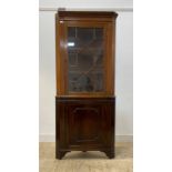 A mahogany two part floor standing corner cabinet, the Georgian top with dentil cornice over