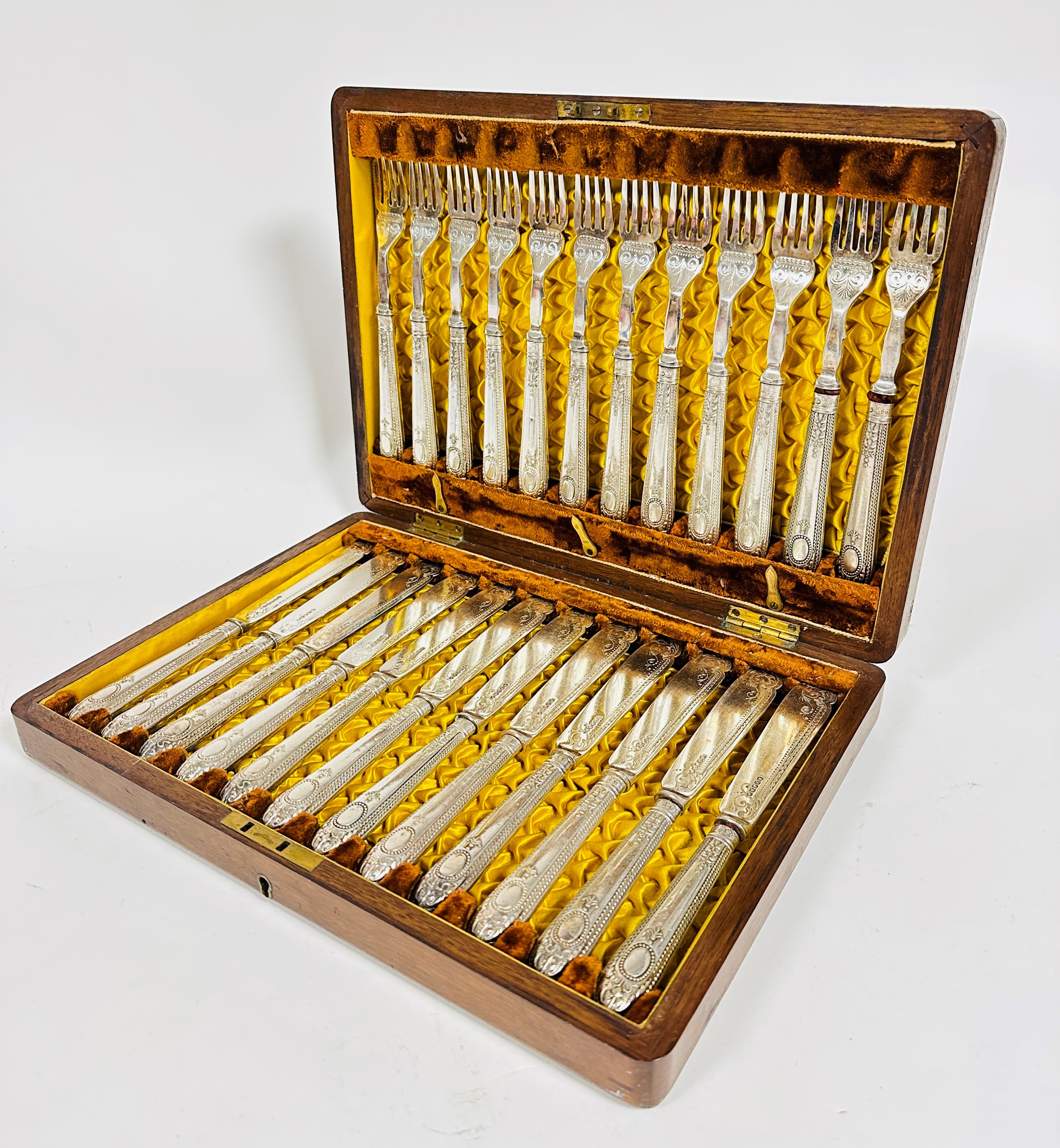 An Edwardian Epns set of twelve pairs of fish knives and forks with beaded handles and engraved