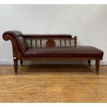 A late Victorian oak framed chaise longue, the arm seat and back rest upholstered in studded faux