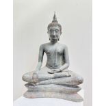 A large bronze patinated seated Buddhist figure with flame to head, cross legged with one arm in his