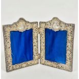 A Victorian white metal mounted double folding photograph frame, the shield mounted top with leaf