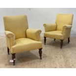 A pair of late Victorian/ Edwardian walnut framed easy chairs, upholstered in yellow silk, raised on