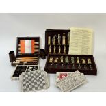 A group of various board games such as a travel set of Backgammon with brown and white counters a