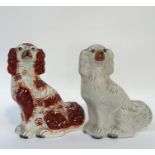 An associated pair of Staffordshire Spaniels, one decorated with orange enamelling with a gold