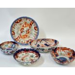 A group of Imari porcelain comprising a plate with garden scene decorated in polychrome enamels of