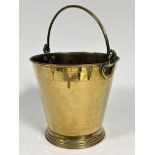 An Edwardian brass coal pail with loop handle to top and heart shaped studded side supports, of