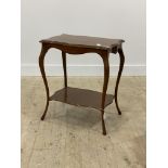 An early 20th century walnut occasional table of serpentine outline, with two tiers, raised on