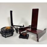 A collection of Chinese rosewood and hardwood stands including a substantial plate stand with centre