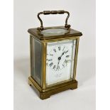 A brass four glass cased carriage clock with enamelled dial and Roman numerals, retailed by H W