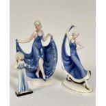 A set of three Katzhutte Art Deco figure of ladies, one holding both hems of her skirt up, (h:
