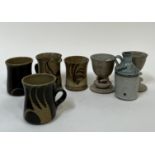 A group of studio pottery comprising a pair of mugs with abstract wax-resist decoration and pulled