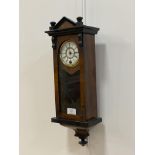 A late 19th century miniature wall clock, the glazed, ebonised walnut case enclosing a white