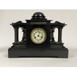 A Victorian slate mantel clock of architectural form, the case with frieze depicting figures in