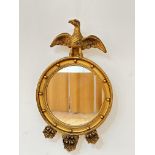 A reproduction gilt plaster ball pattern Regency style mirror with eagle surmount with centre