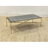 A mid century style gilt metal coffee table, the distressed mirrored glass top raised on rod