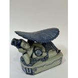 A modern Chinese blue and white porcelain headrest/pillow modeled as a reclining female under a
