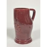 A Dunmore moulded shaped tankard of sculpted form with shaped handle to side and embossed centre