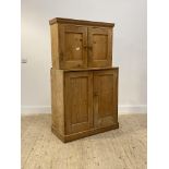A 19th century pine side cabinet, the top section fitted with two panelled doors opening to a