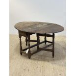 An 18thc oak drop leaf table, the oval top over drawer to one end and gate leg turned and block