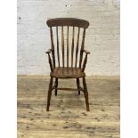 A Victorian elm and beech Windsor chair, the comb back over open arms, shaped saddle seat, raised on
