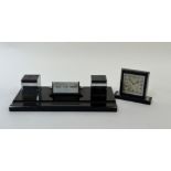 An Art Deco style black glass writing desk set with a built in table calendar, ink well set and